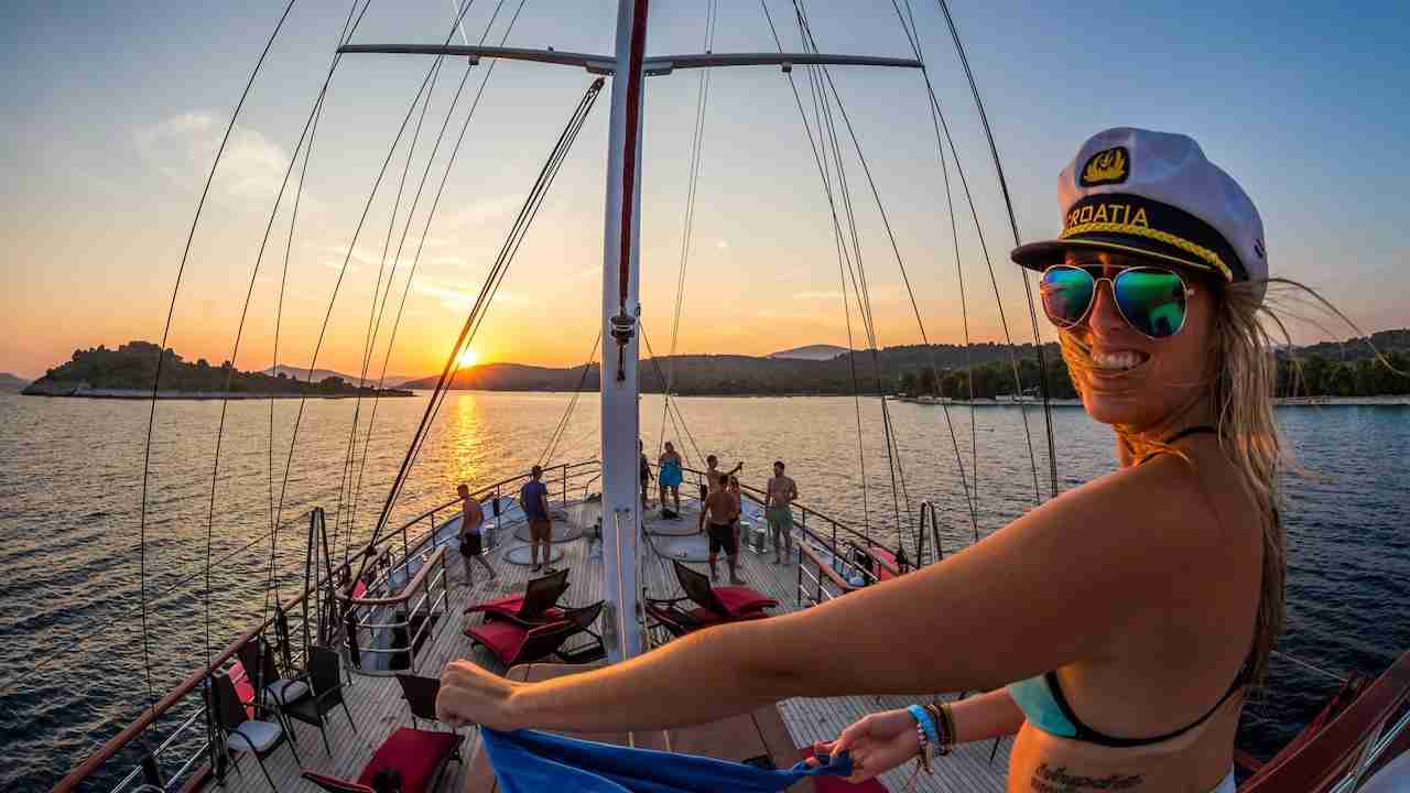 girl with a captain hat on a boat party in Thailand during the sunset