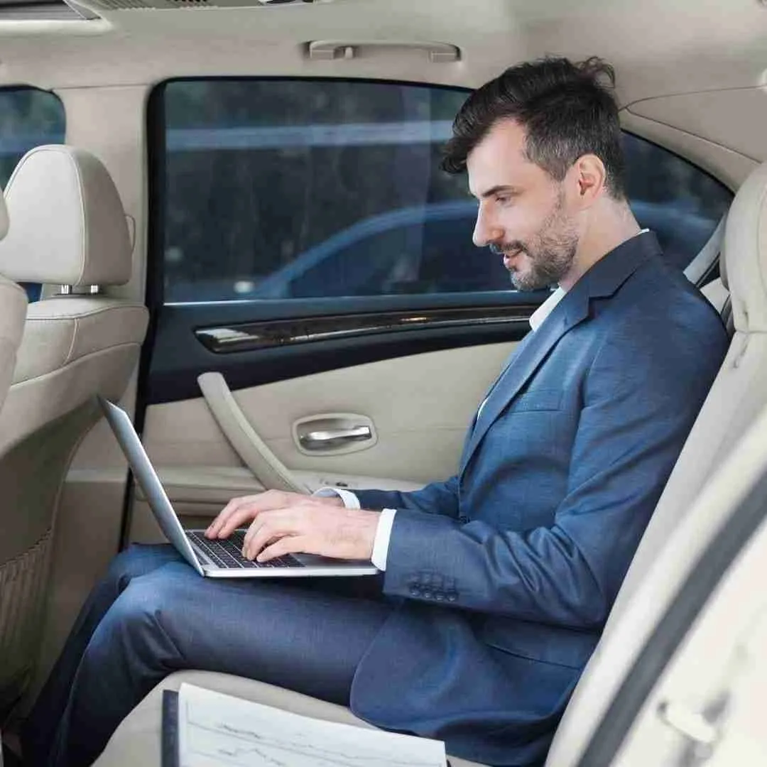 businessman working on his laptop inside a limousine
