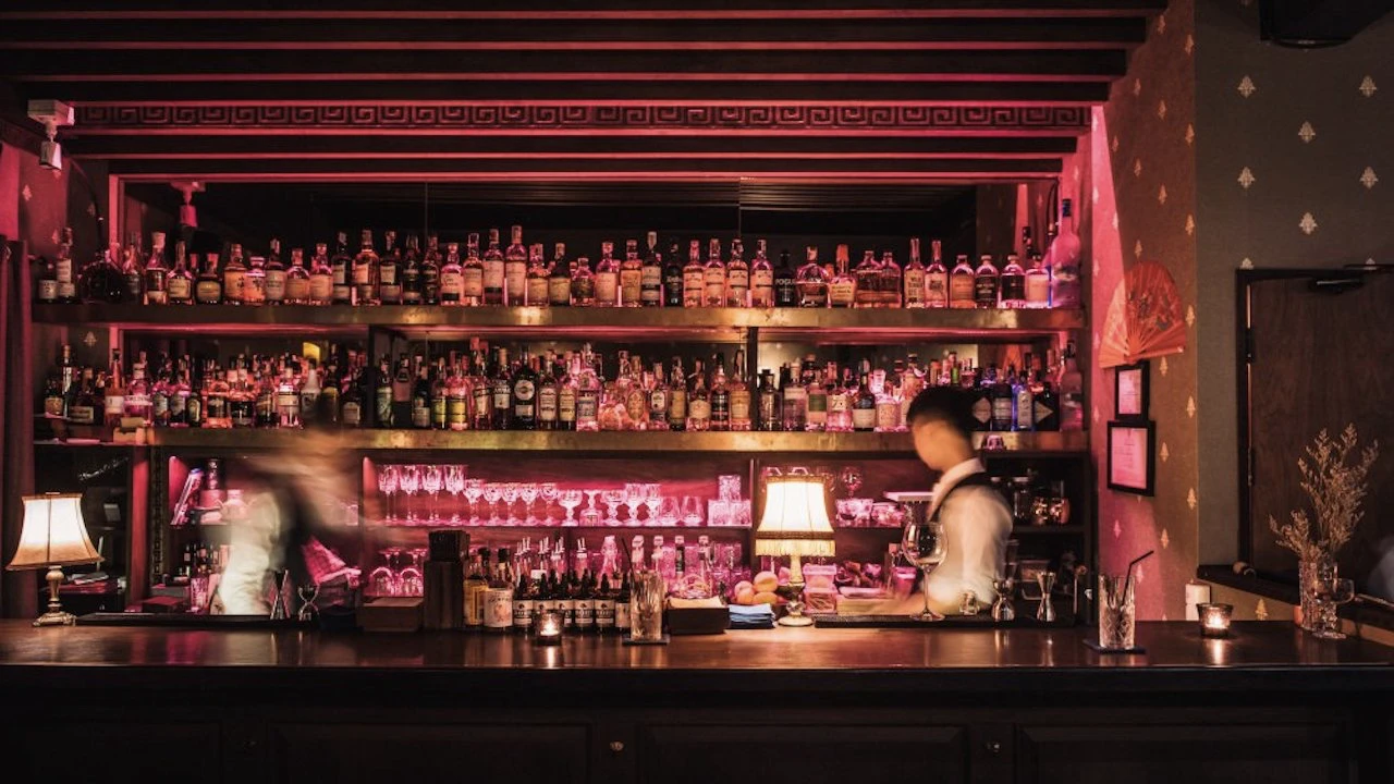 view of the counter and bartenders in dim pink light at honest mistake bar in bangkok