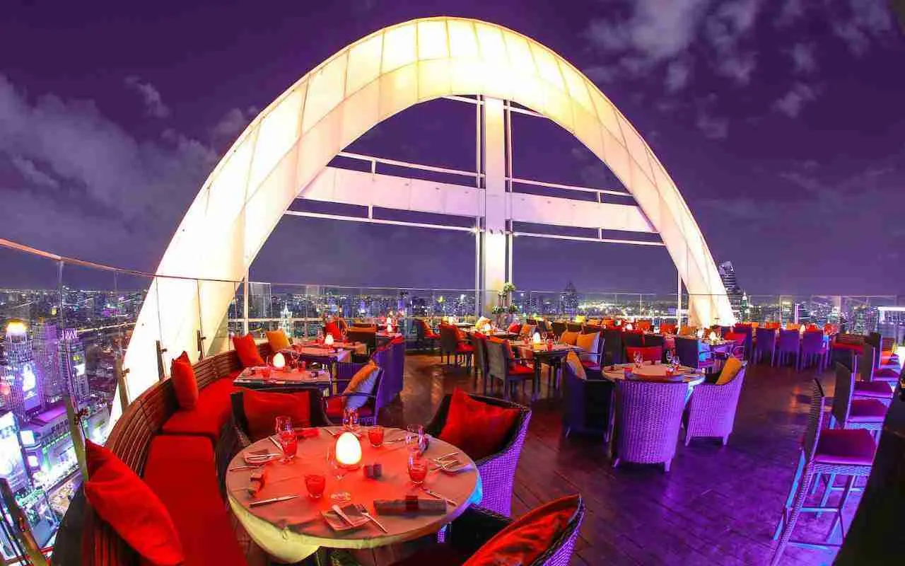 Red Sky Rooftop Bar Bangkok at night with tables and lights