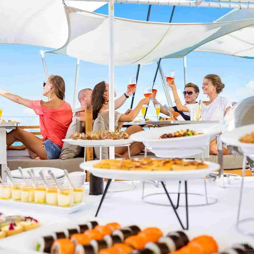people drinking and eating from a buffet during a boat cruise in Thailand
