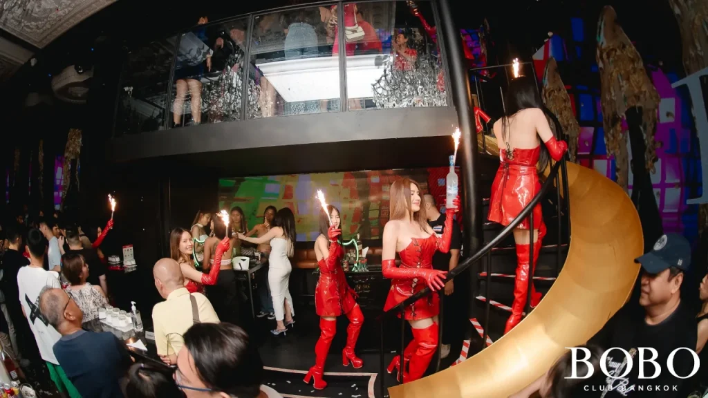 the vip mezzanine with a slide and girls walking up the stairs with sparklers at Bobo club Bangkok