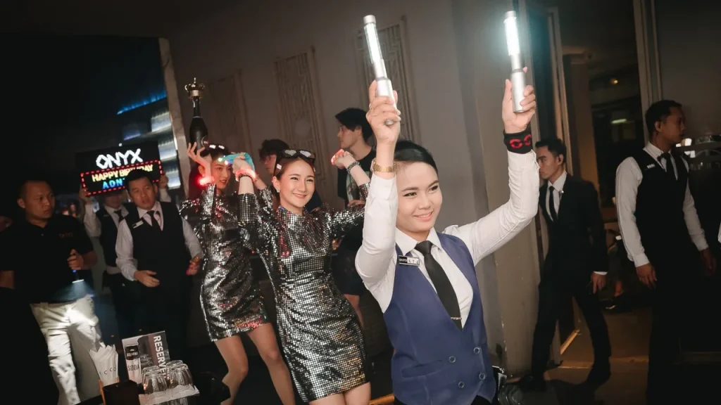 waitresses walking to a VIP table with bottles and lights at the Onyx club in Bangkok