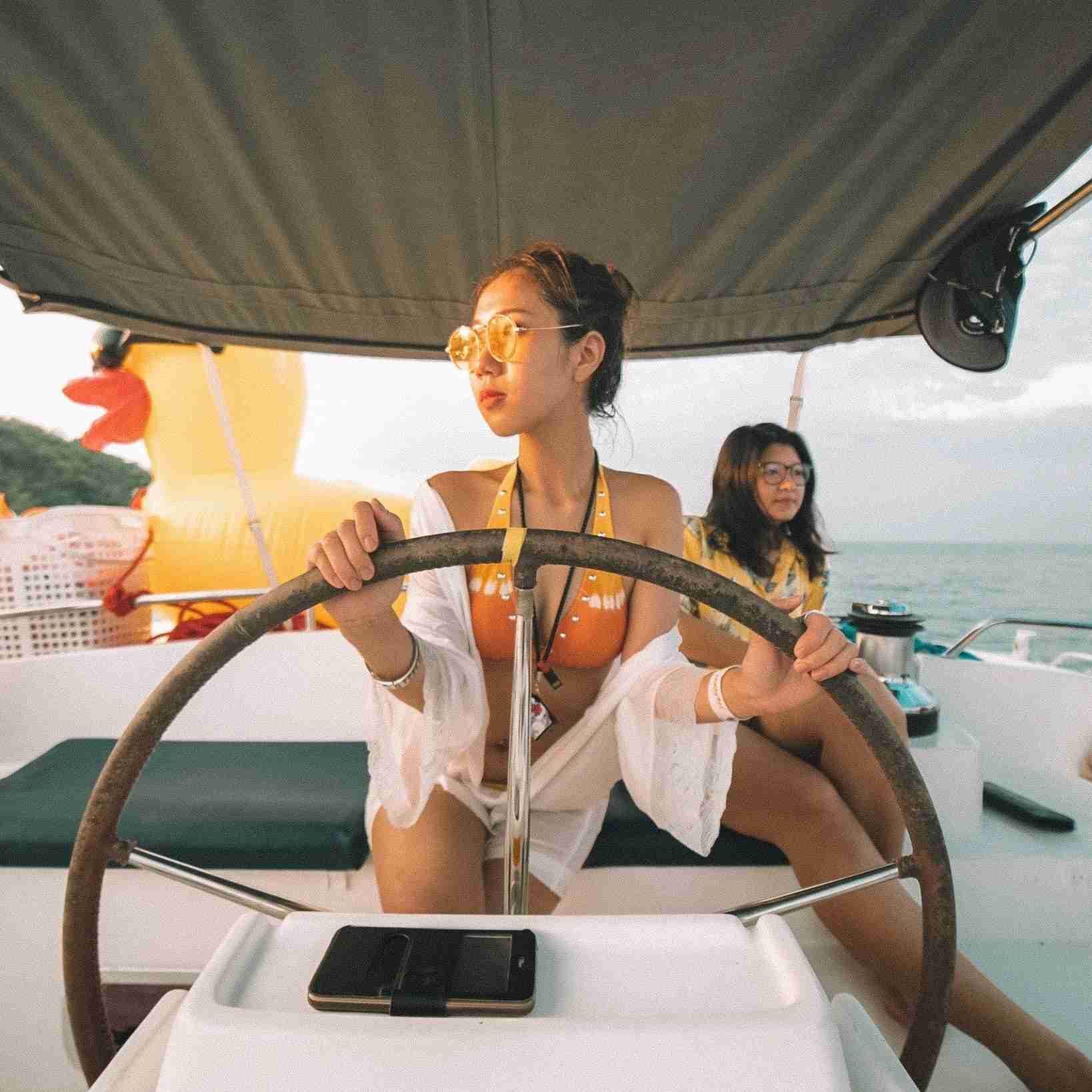 Thai girl driving a yacht in Phuket